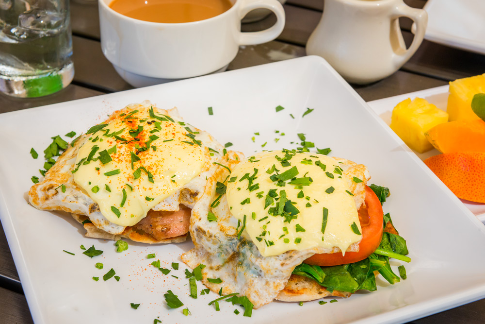 Anuinui_Cafe-002-web Keanu Reeves eggs Benedict ($16): one veggie and one with kalua pork; seasonal fruit plate ($6) and a cup of Pakala blend coffee. Daniel Lane photo.