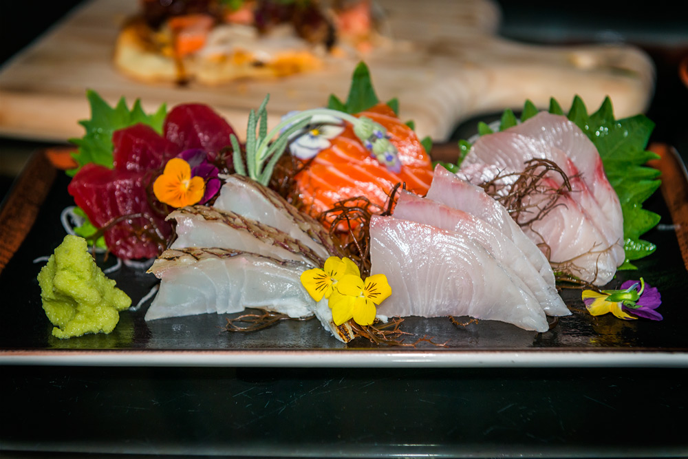 Stevensons-010-web Sashimi at Stevenson's Library includes freshly grated horseradish, fans of big eye tuna, snapper, salmon, Big Island Kampachi and hamachi garnished with ogo (purple seaweed, rosemary and pansy flowers, shisho leaves and daikon spirals. Daniel Lane photo.