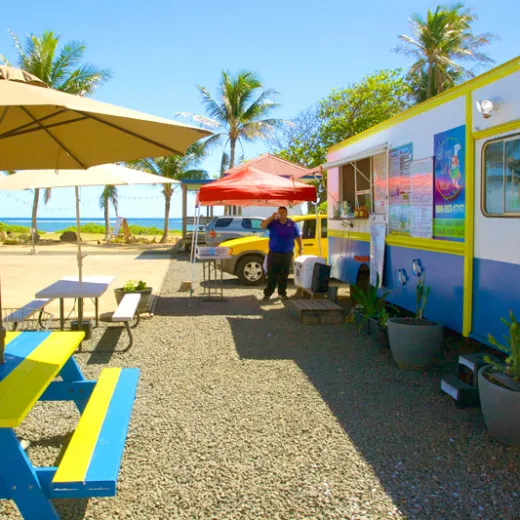 a group of lawn chairs sitting on top of a blue umbrella